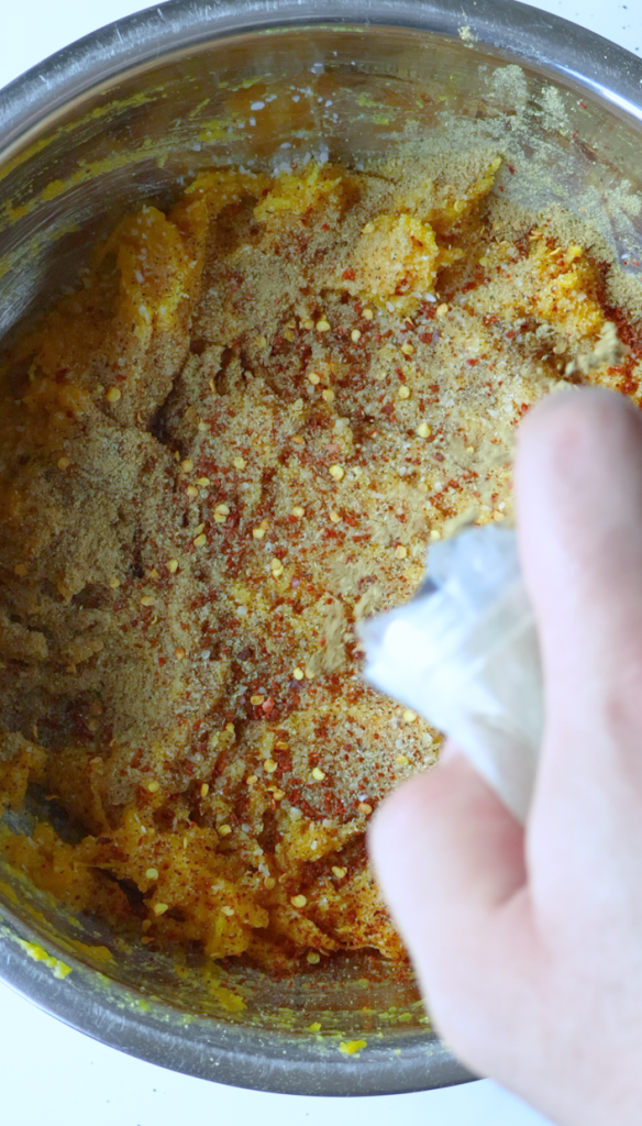 Remove the skin from your baked pumpkin, then mash pumpkin with chopped cilantro, black pepper, red chili flakes, coriander, garlic powder and salt.